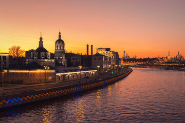 Obraz premium The Moskva river embankment in front of a Moscow cityscape against the sky at autumn sunset