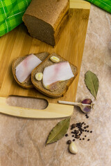 Bread with bacon and garlic on a wooden board.