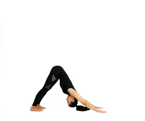 Woman doing yoga asana in white background. Black outfit. Ashtanga, Vinyasa, Hatha