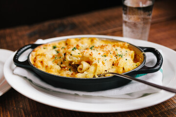 Mac and Cheese with butternut squash and bacon in a cast iron dish - obrazy, fototapety, plakaty