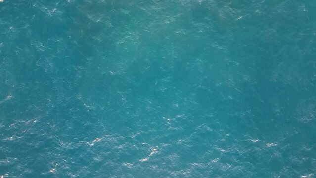 Top view of calm water surface. Aerial view of the sea waters. Ocean surface without waves in the daylight. Water outdoors concept. Water texture.