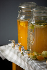 Natural fruit content refreshment cold drinks in glass containers outdoor, on tabletop.
