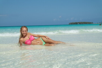 Fototapeta na wymiar beautiful Blond Hair Young, sporty body and sexy girl woman in bikini posing relaxing on the tropical beach in caribbean