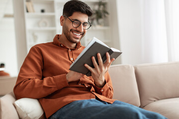 Smiling Arab man in glasses reading book