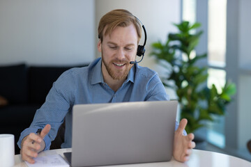 Caucasian man at home remote working at home on laptop computer talking to a colleague