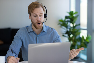 Caucasian man at home remote working at home on laptop computer talking to a colleague