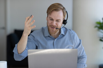 Caucasian man at home remote working on laptop computer talking with his colleague