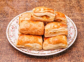 Homemade potato patties in a dish isolated on dark wooden background top view