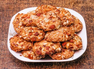 traditional almond cookies ameretti biscuits in dish isolated on dark wooden background top view