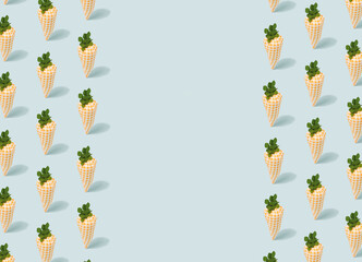 Cute toy carrots pattern on a light blue background with copy space.. Springtime, Easter minimal template.