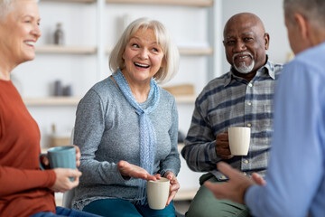 Multiracial group of positive elderly people drinking tea, chatting