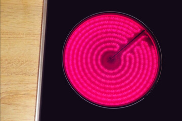 Red hot glass ceramic cooktop burner flame. Glowing burner of the electric hotplate, top view - obrazy, fototapety, plakaty