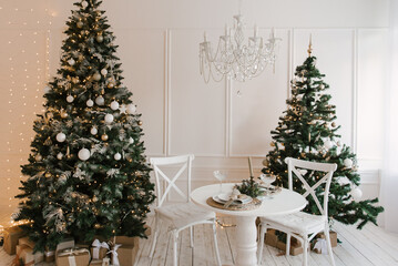 Stylish bright interior of the living room with a Christmas tree and a festive table