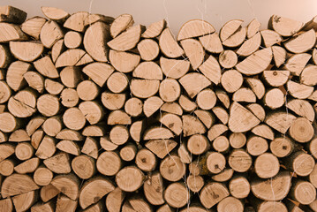 Background of dry chopped firewood logs stacked up on top of each other in a pile
