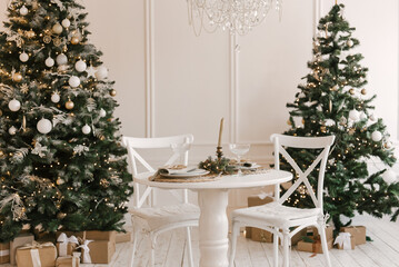 Stylish bright interior of the living room with a Christmas tree and a festive table