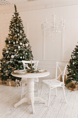 Stylish bright interior of the living room with a Christmas tree and a festive table