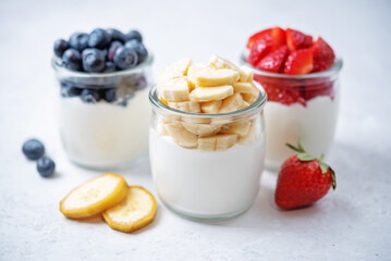 Set of Greek yogurt strawberry blueberry banana parfait in jars
