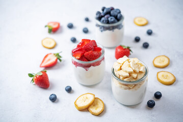 Set of Greek yogurt strawberry blueberry banana parfait in jars