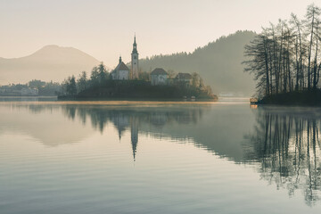 Fototapeta na wymiar Beautiful view to Lake Bled, the most famous Slovenian lake and island Bled with Pilgrimage Church of the Assumption of Maria at dawn