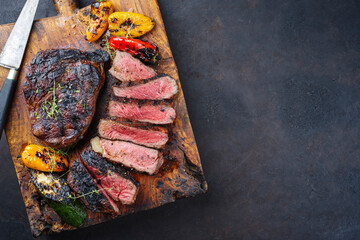 Traditional barbecue dry aged wagyu rib-eye beef steaks served with paprika and zucchini as top...