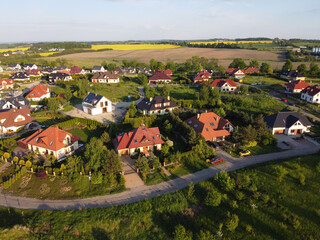 Residential neigborhood in sunset, bird eye view. Suburbs or village streets with luxury house buildings