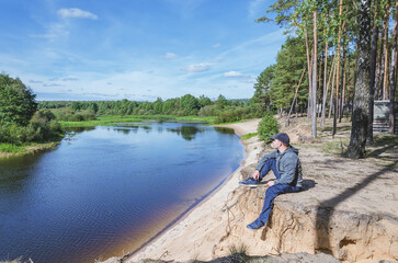 Fototapeta na wymiar Man relax on the river bank.