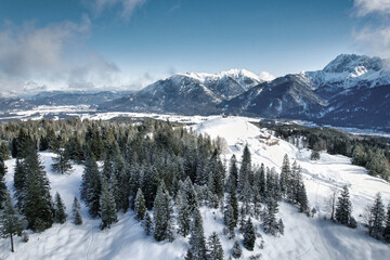 Karwendel - winter landscape with snow covered mountains, forest and clouds in the sky