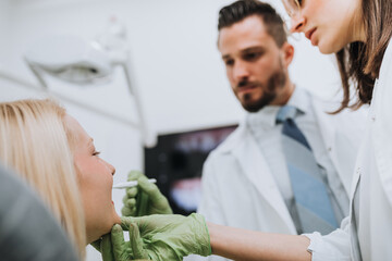 Obraz premium Beautiful young blond woman having dental treatment at dentist's office.