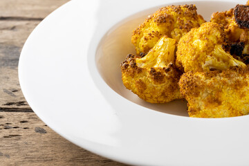 baked cauliflower with curry on white plate