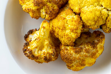 baked cauliflower with curry on white plate