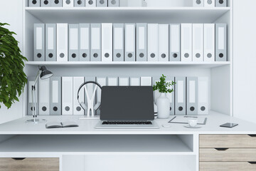 Close up of contemporary designer desktop with folders bookcase, empty laptop screen, coffee cup, decorative plant and other items. Mock up, 3D Rendering.