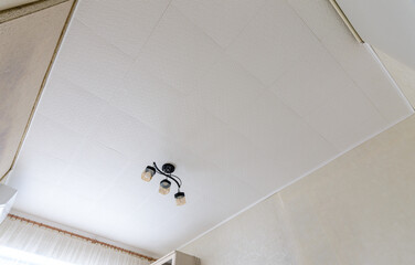 Modest ceiling with glued ceiling tiles and a small chandelier