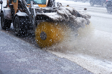 Snowblower at work on a winter day. City after blizzard. Snow cleaning tractor removing snow