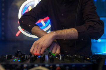 Close up view of a dj's hands playing the mixer while performing