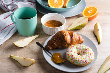 Healthy breakfast. Croissant, donut, coffee, jam, fruits: oranges and pears.