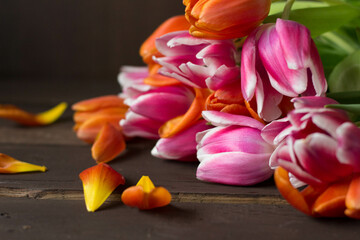 pink and orange tulips on dark brown wooden ground