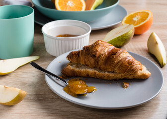 Healthy breakfast. Croissant, donut, coffee, jam, fruits: oranges and pears.