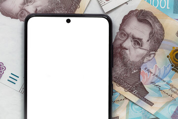 white smartphone screen on 1000 Ukrainian hryvnia banknotes background