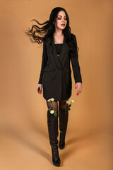 Young woman walking with a white roses in her boots
