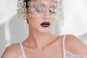 Fashion beauty close-up portrait of girl with black glossy lips, blue eyeshadows. crown of crystals