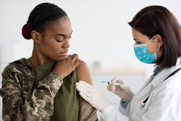 Military Vaccination. African American Soldier Lady Getting Vaccine Shot Against Coronavirus