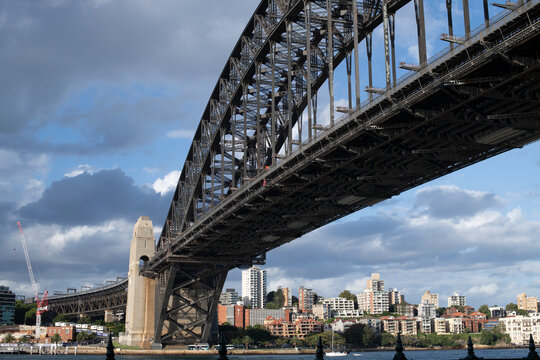 View Of Sydney Harbour Bridge From The City To Blues Point. Apartment Blocks Fill The Scene. A Construction Site With A Crane To The Left Where A Tunnel For The New Sydney Metro Is Being Built.