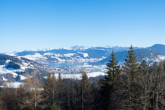Bautiful winter landscape in Switzerland: View towards lake Aegeri with surrounding snow-covered hills and mountains