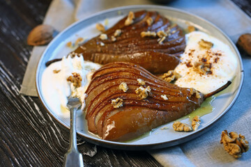 Caramelized pear with nuts and buttercream on a plate. Healthy dessert.