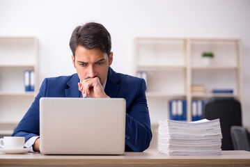Young male employee and too much work in the office