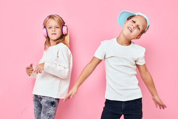a boy in a cap and a girl are playing together pink color background