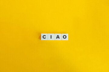 Ciao word on letter tiles on bright orange background. Minimal aesthetics.