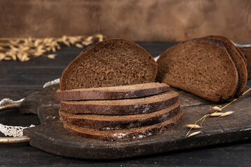 Homemade sourdough sliced bread loaf. Rye ears on the background. Close-up.