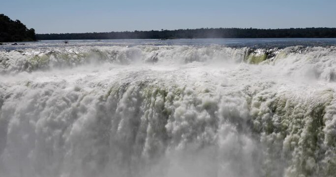 Slow motion shot of Iguazu waterfall. The beautiful falling water texture and pattern creating a mist.