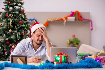 Young man celebrating Christmas at home alone